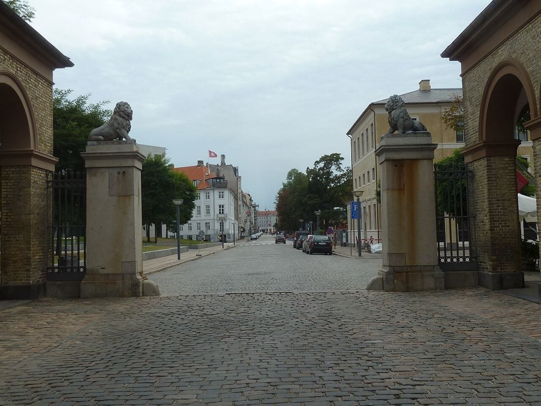 Cobbled Esplanaden seen through a gate flanked by lion sculptures