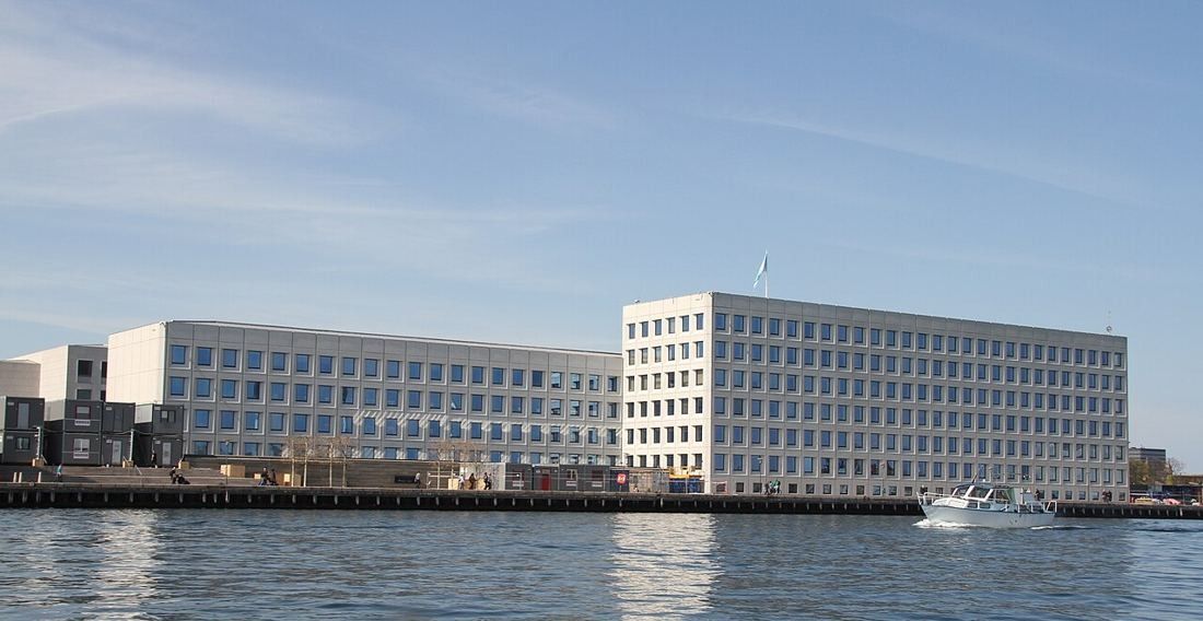 Long pale office building with a grid of square windows on the Copenhagen waterfront
