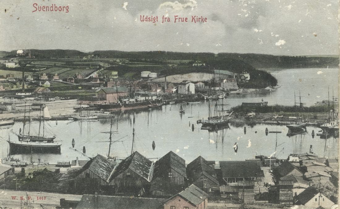 Old postcard view over rooftops to a harbour full of sailing ships