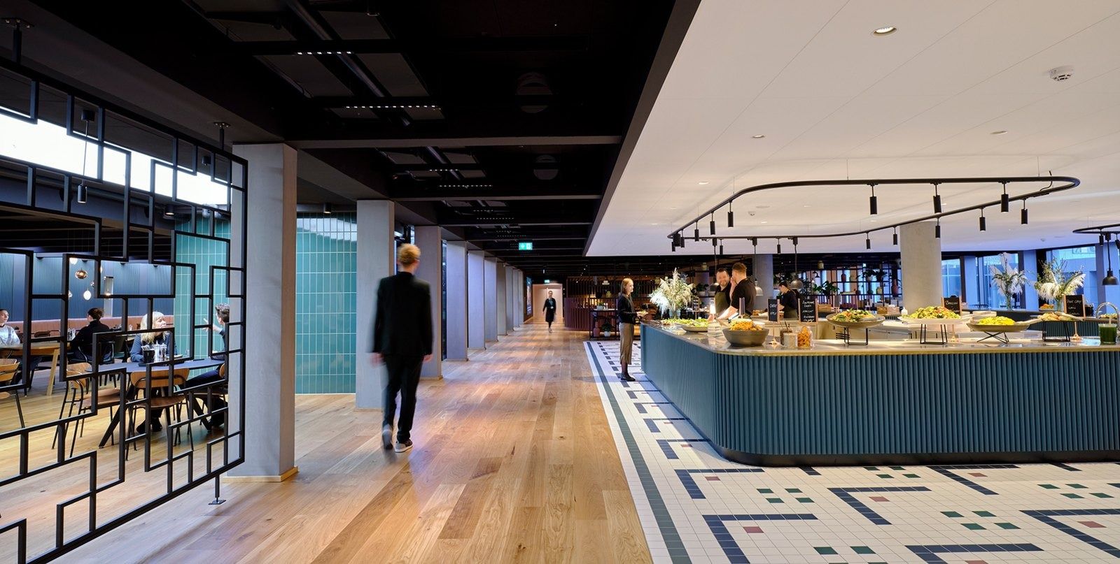 A.P. Moller - Maersk: Long dining hall with oak floor, patterned tile path and a curved buffet counter with dark ceiling