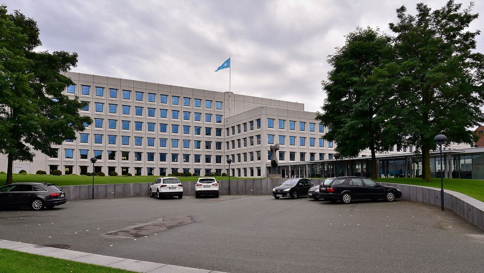 A.P. Moller - Maersk: The building behind a lawn and parking area with a flag on the roof