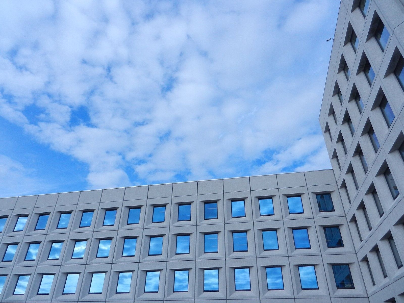 A.P. Moller - Maersk: Upward view of the concrete window grid against a cloudy sky