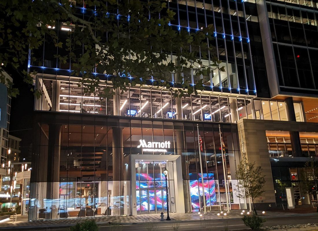 Marriott International: Glass ground floor of the tower lit up at night with a Marriott sign above the entrance