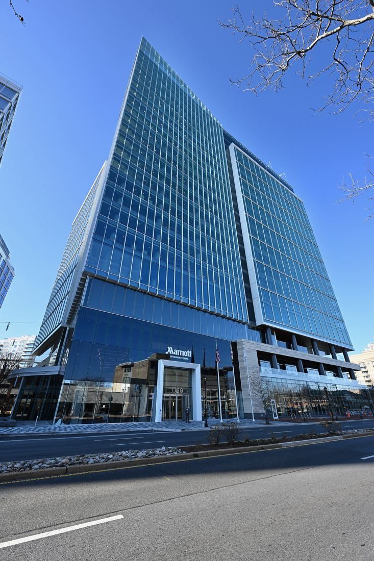 Marriott International: Glass tower with an angled corner seen from the street under a blue sky