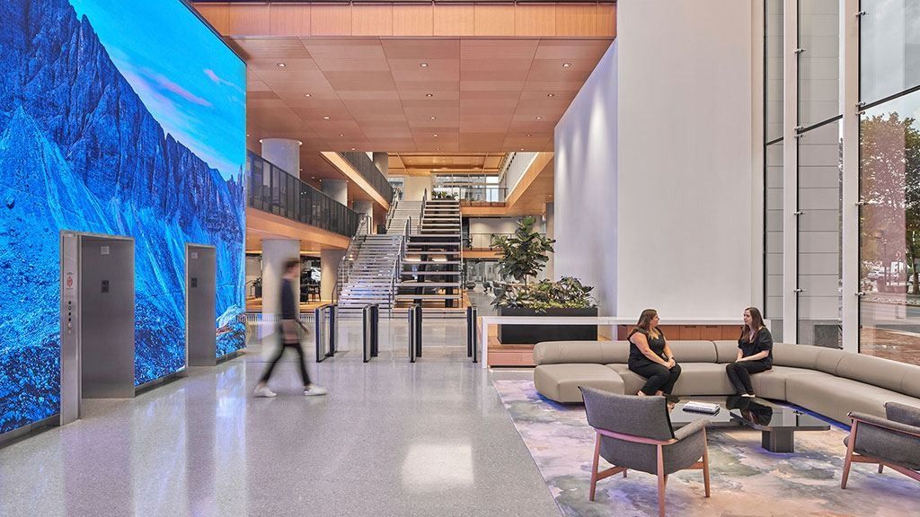 Marriott International: Lobby with a tall digital screen wall around the elevators, turnstiles and a lounge sofa