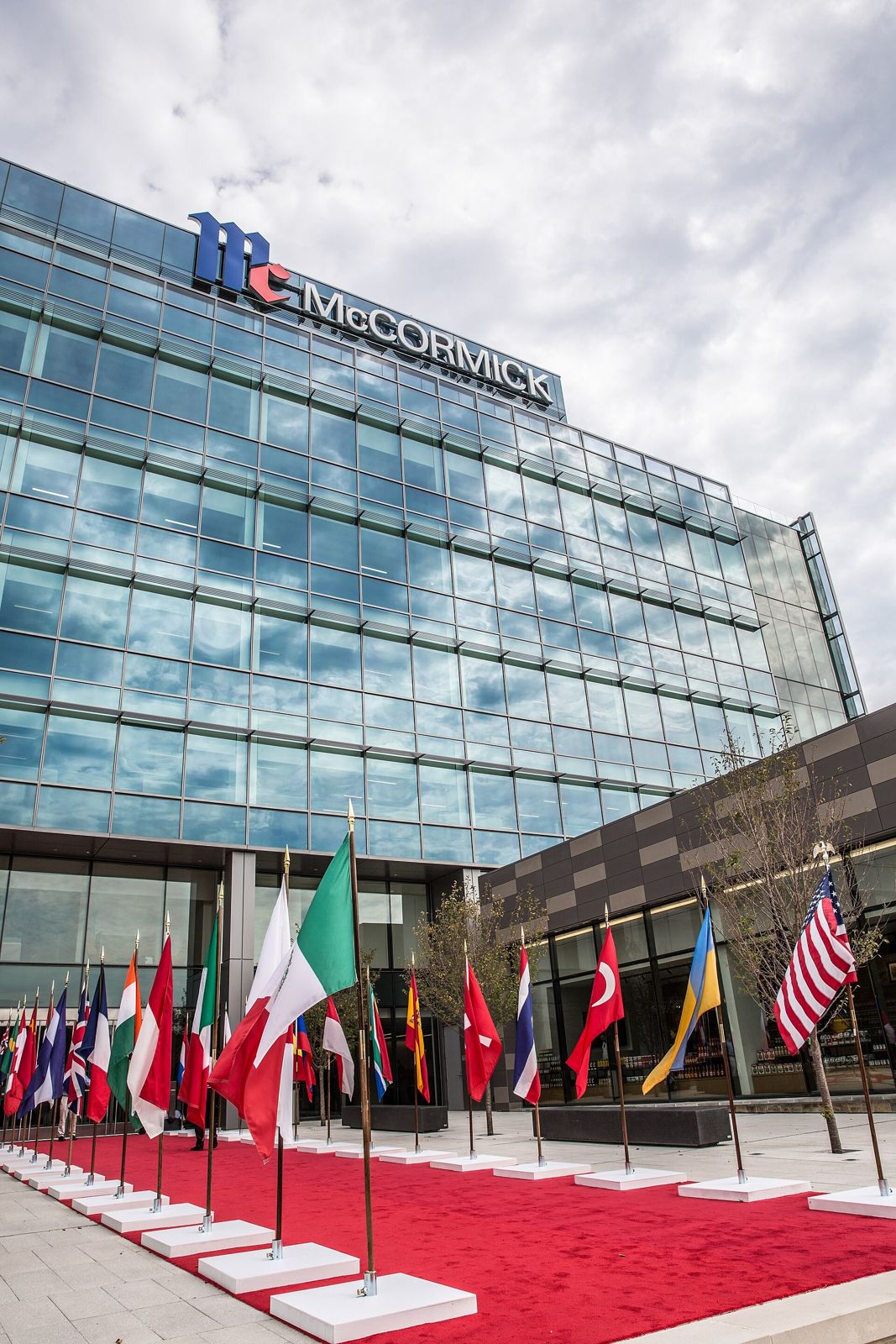 Flags and a red carpet in front of the new glass headquarters