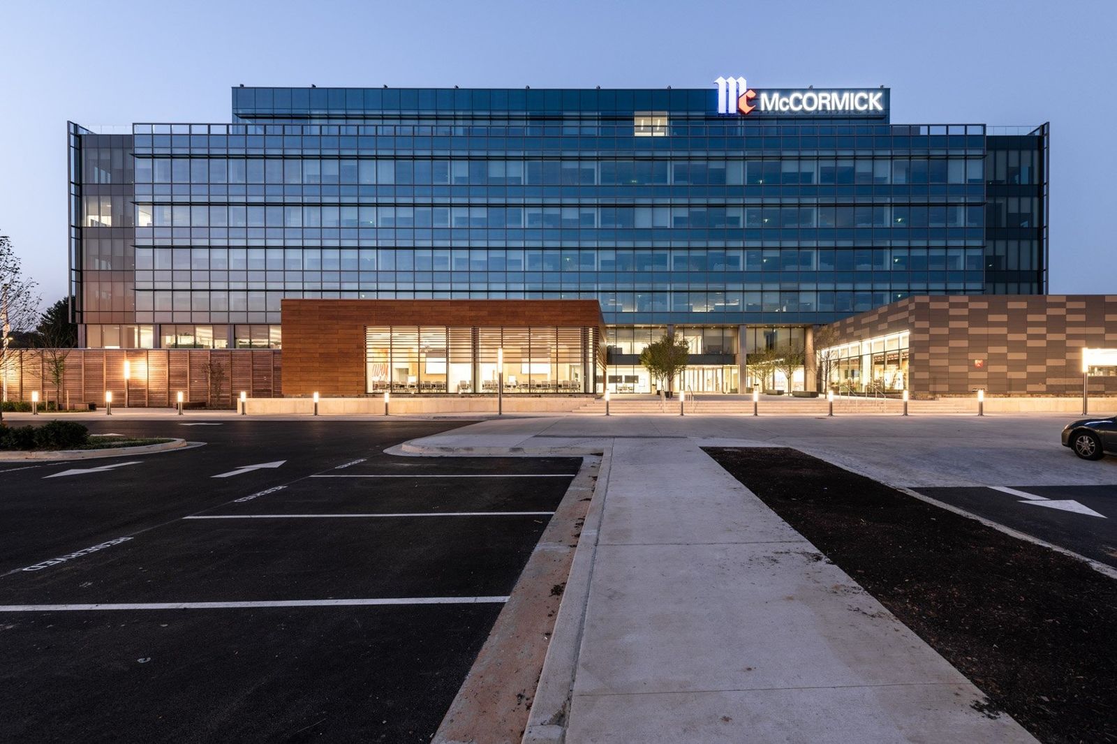 Glass office building with the McCormick name lit at dusk