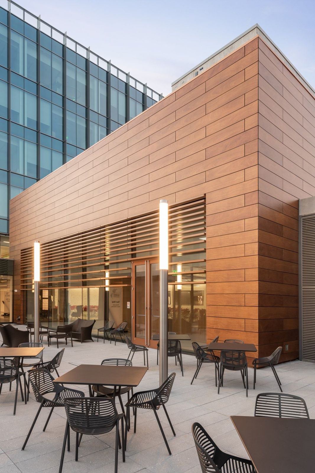 McCormick: Patio tables beside a wood-clad pavilion