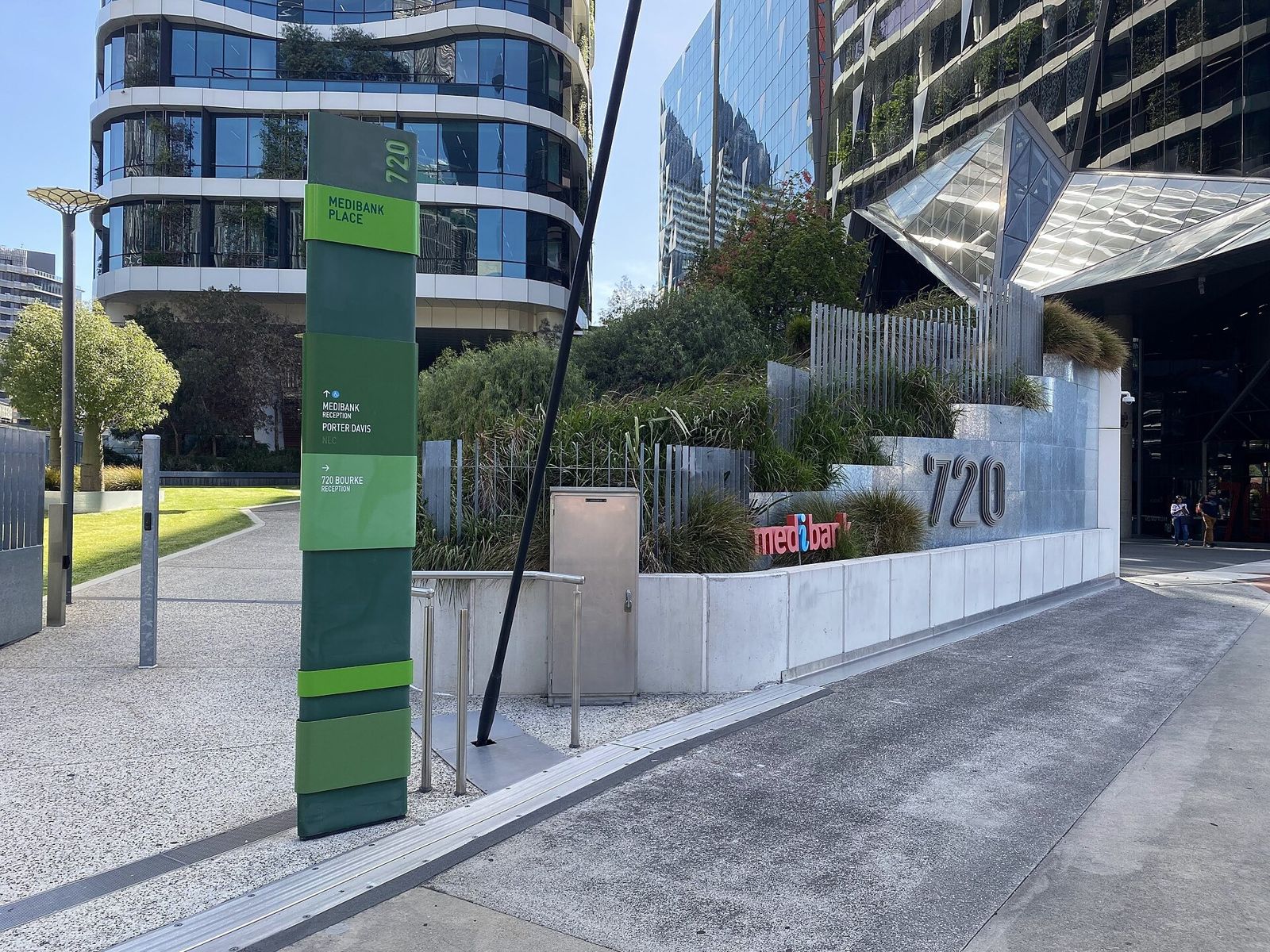 Medibank: A green street sign and planted steps beside the entrance marked 720
