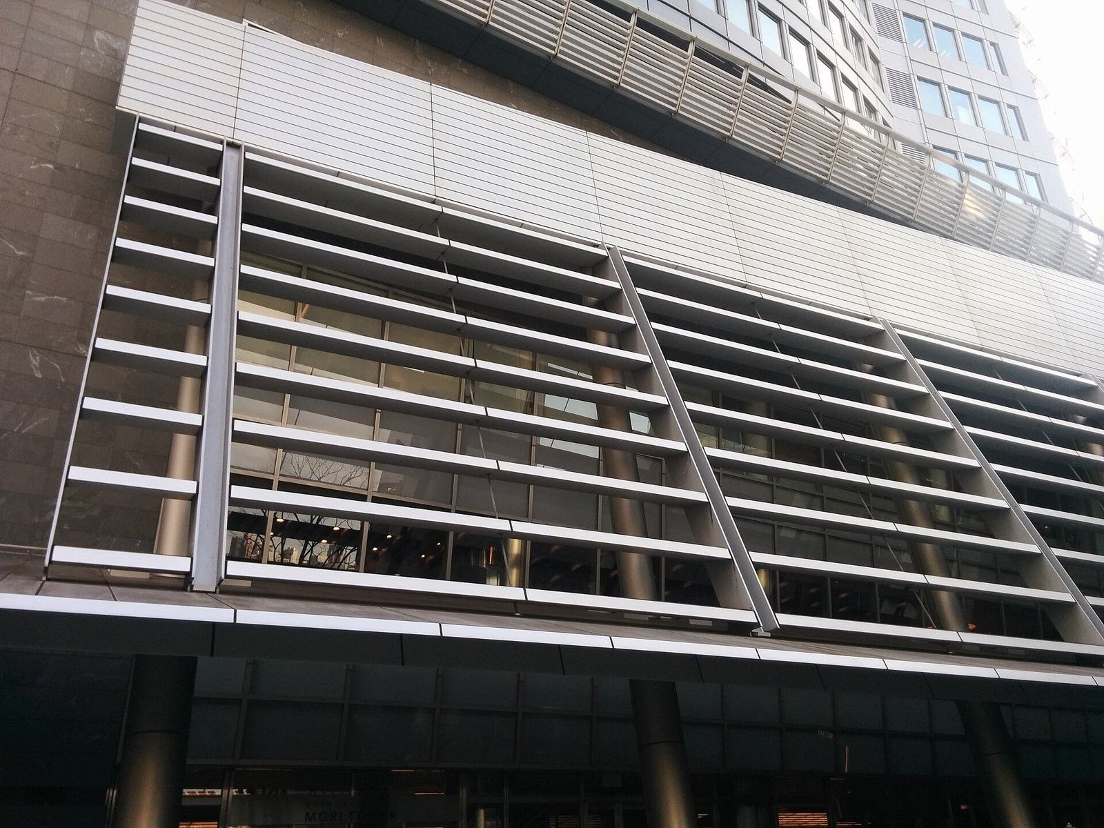 Mercari: Glass canopy and metal louvres at the tower's base