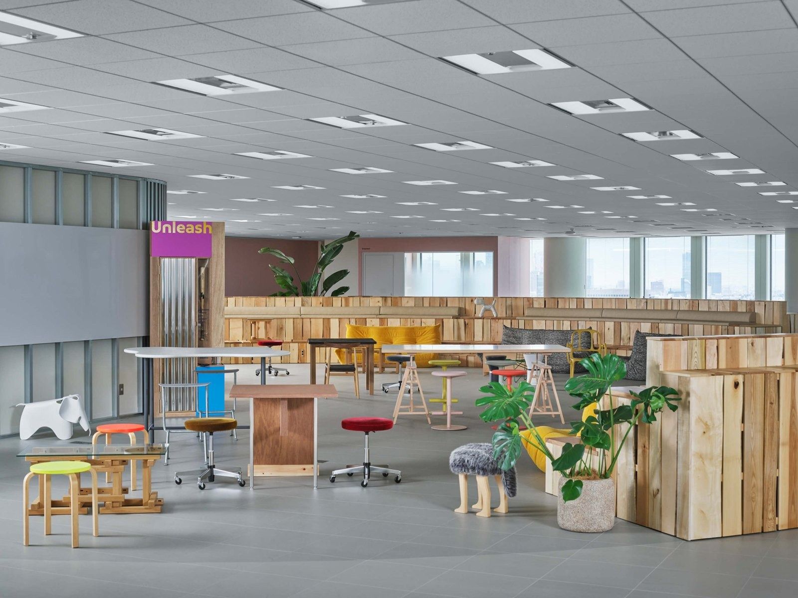 Mercari: Office floor with wooden counters, colourful stools and plants