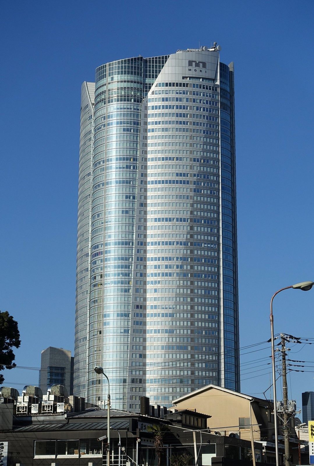 Mercari: Rounded glass tower above low buildings
