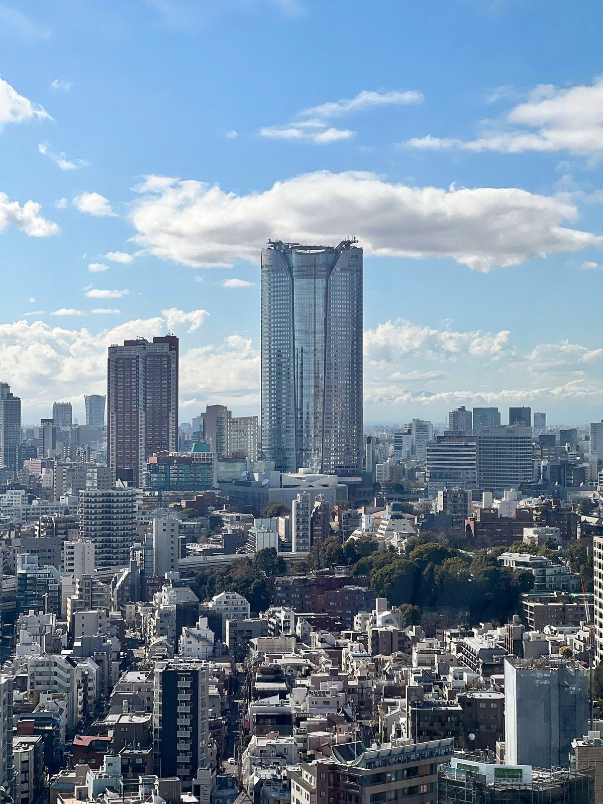 Mercari: Tower rising above the city under clouds