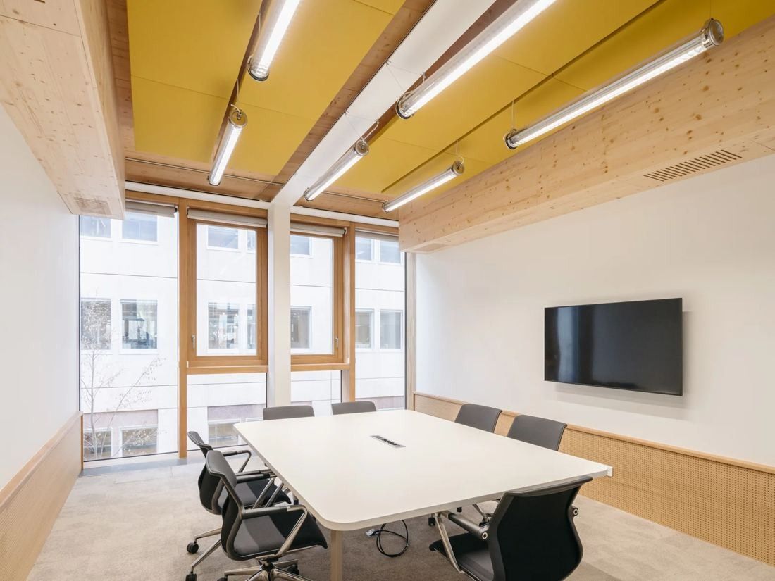 Michelin: Meeting room with a white table, black chairs, a screen and timber ceiling