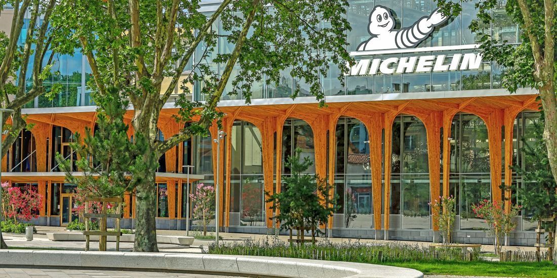 Michelin: Orange timber arches and glass upper storey seen through trees