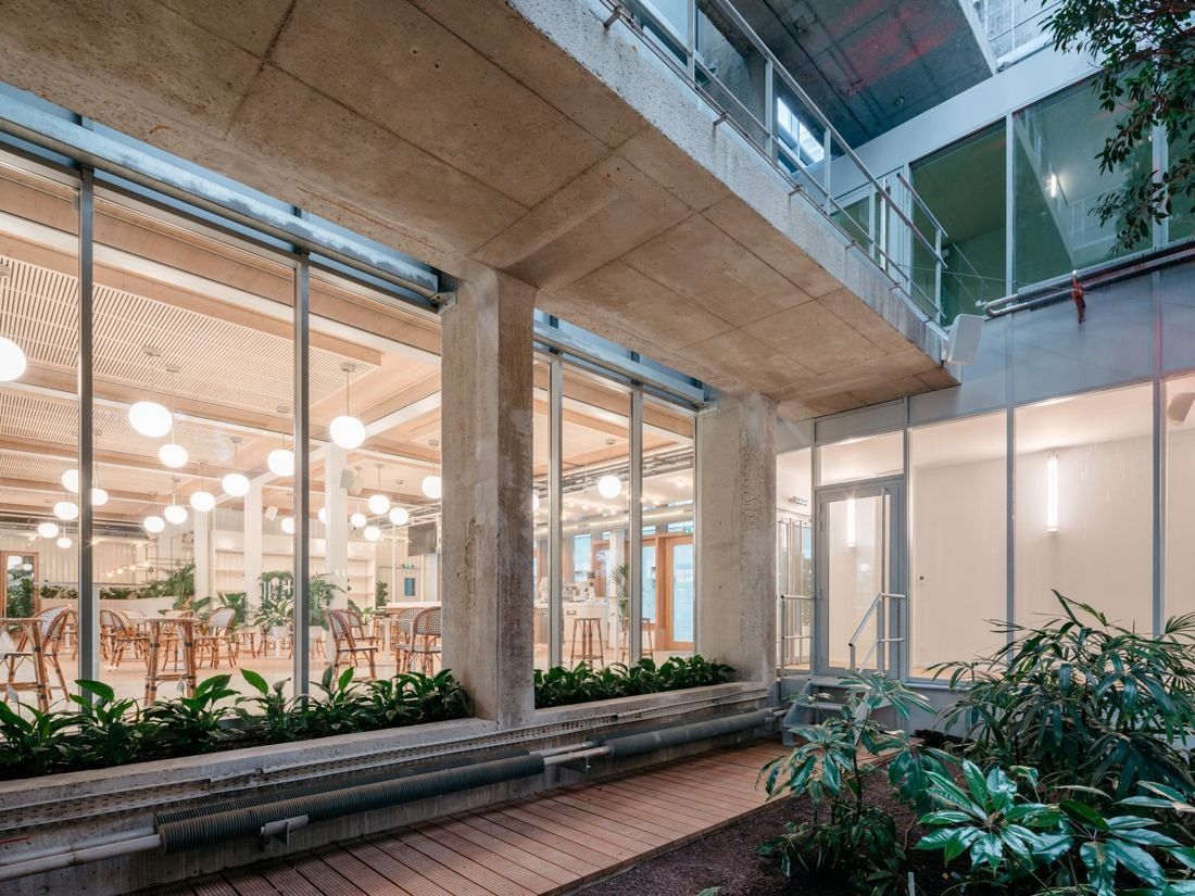 Michelin: Restaurant seen through glazing from a planted terrace under a concrete overhang