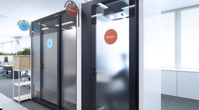 Mitsubishi Corporation: Black phone booths in a white office