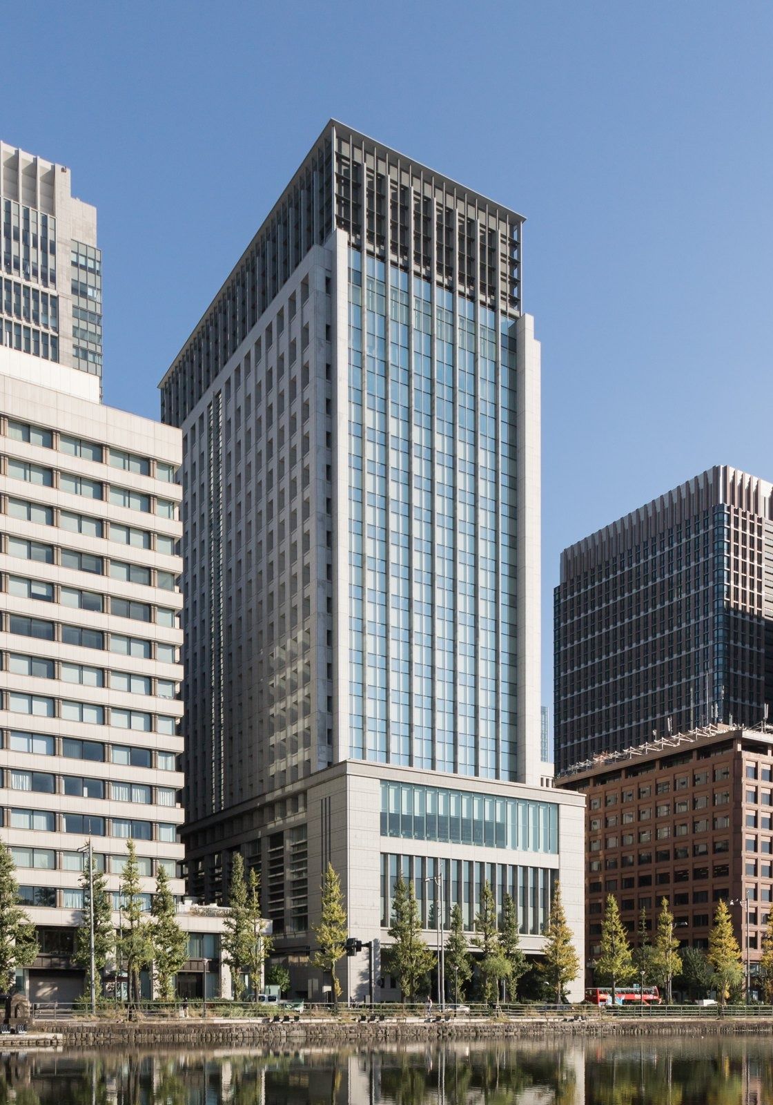 Glass-and-stone office tower on a corner above a moat