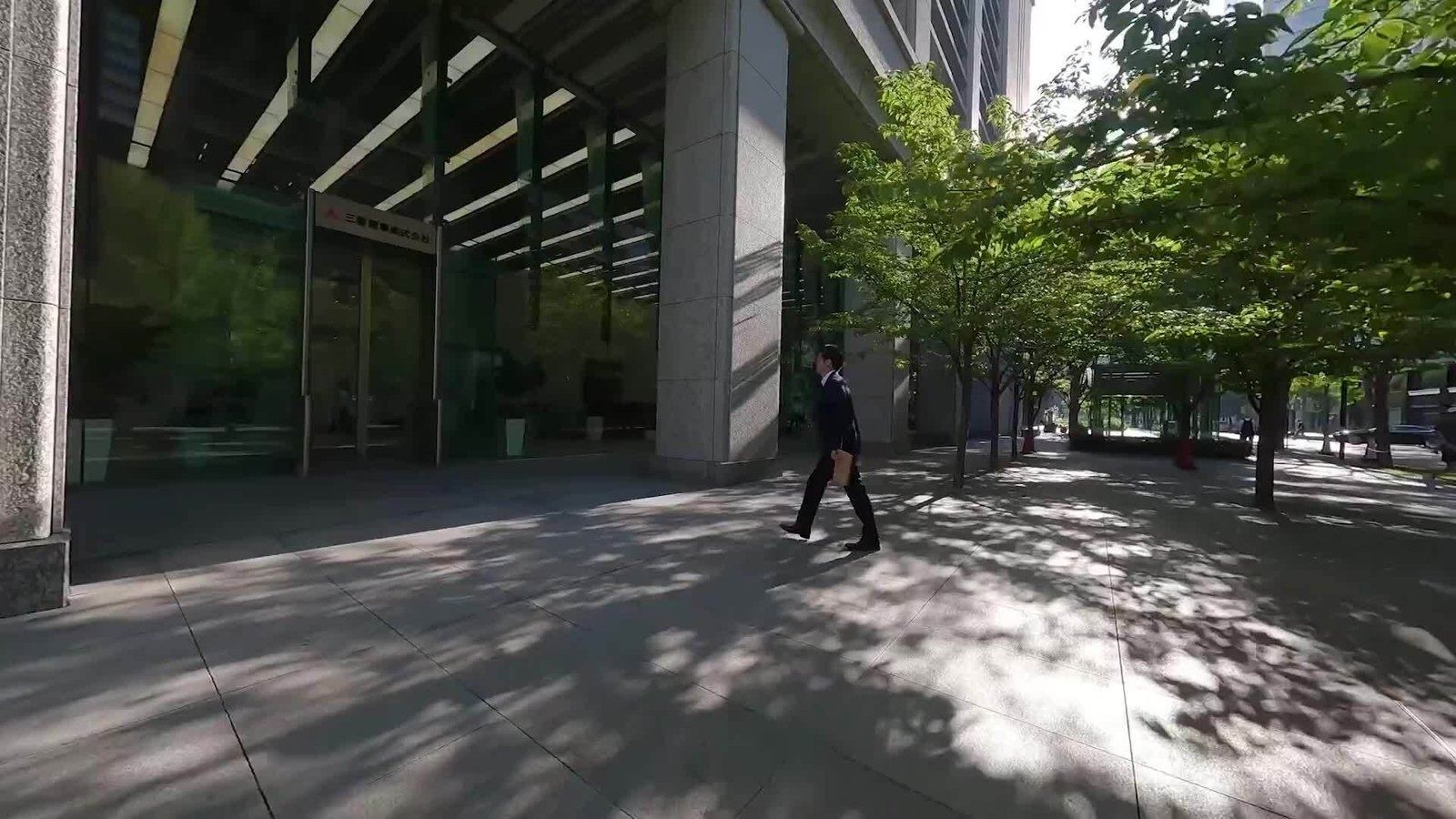 Mitsubishi Corporation: Tree-lined walkway beside a glass building base