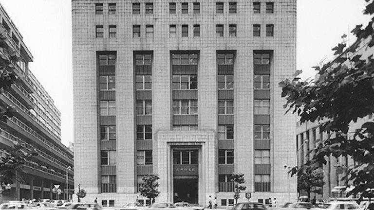 Black-and-white photo of a stone office building with tall vertical windows