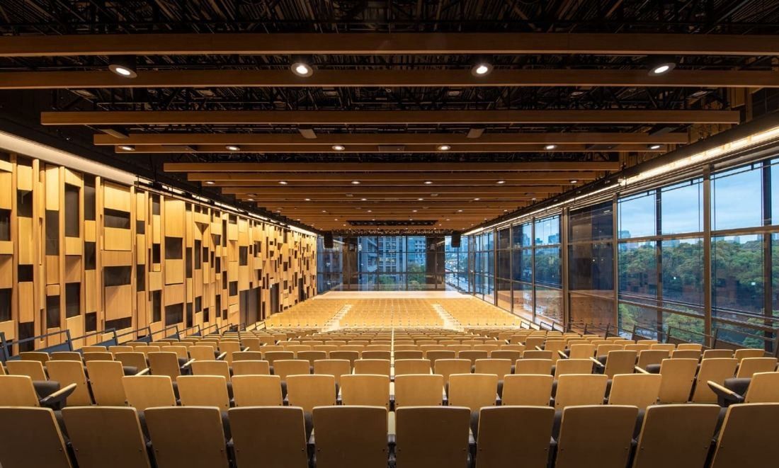 Mitsui & Co.: Hall with rows of chairs facing a stage, wooden panelled walls