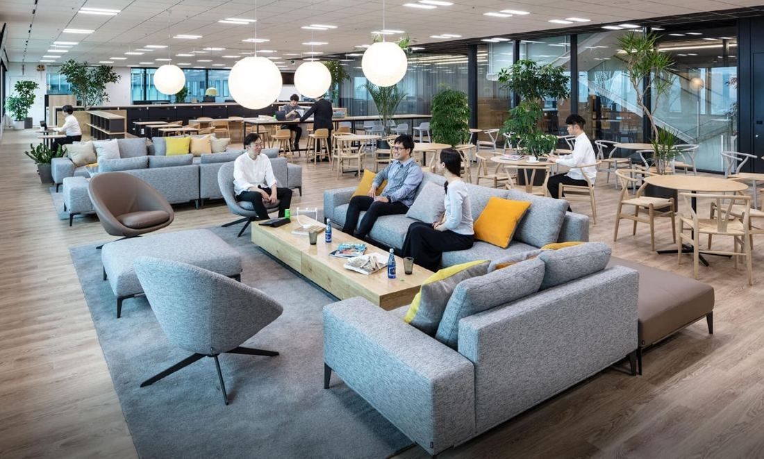 Mitsui & Co.: Lounge with grey sofas, yellow cushions and globe pendant lamps