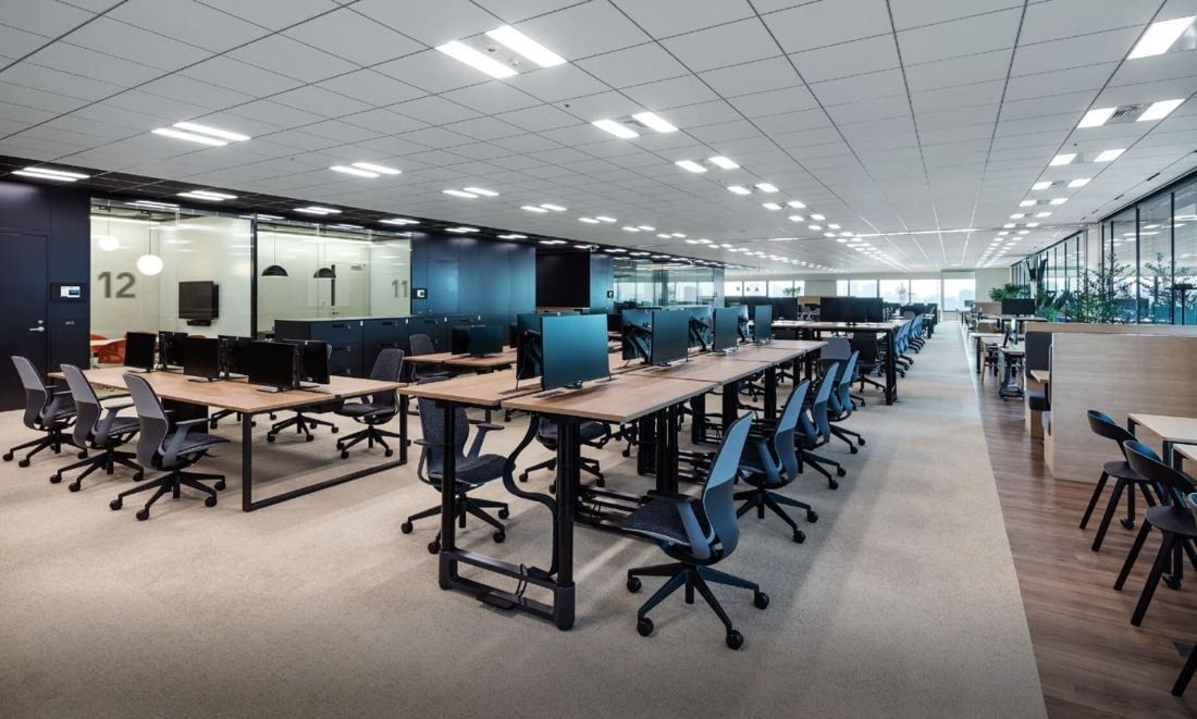 Mitsui & Co.: Rows of desks with monitors and blue chairs in an open office