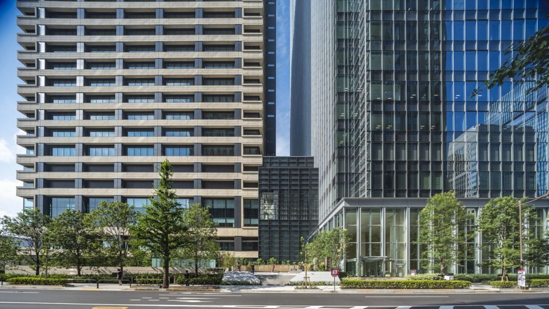 Mitsui & Co.: Two towers rising behind street trees, a striped stone facade on the left