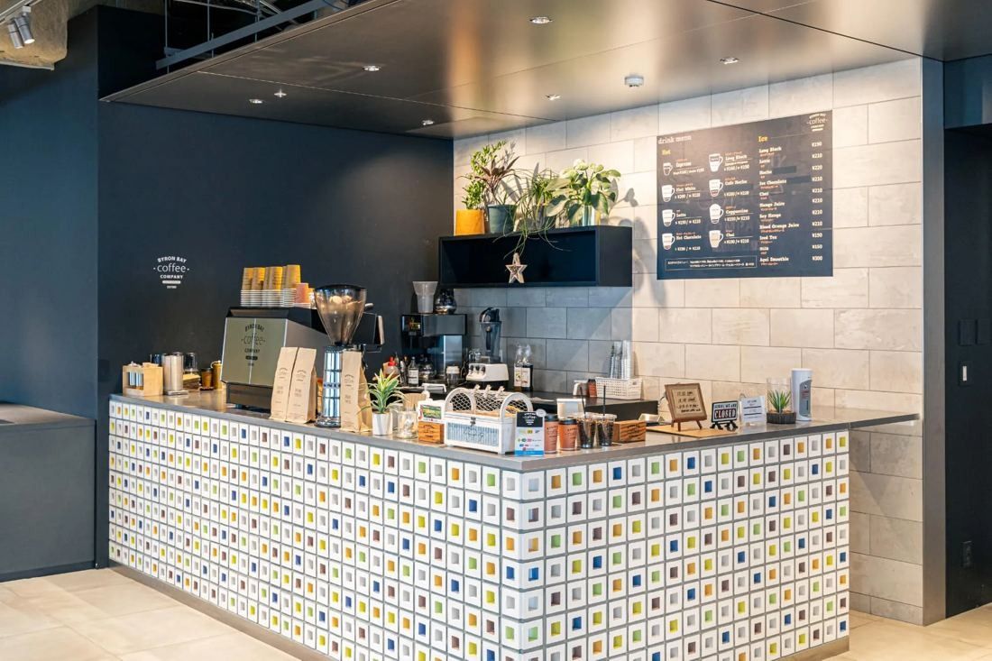 MIXI: Café counter with patterned tiles, coffee machines and a menu board