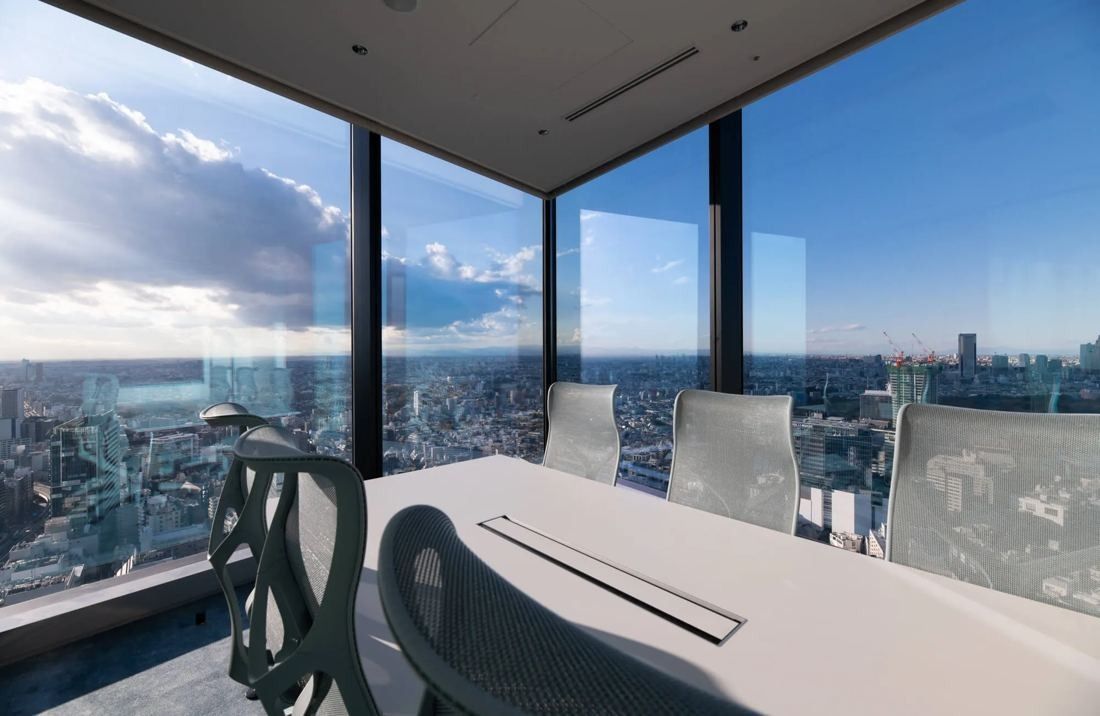 MIXI: Corner meeting room with glass walls and a wide city view