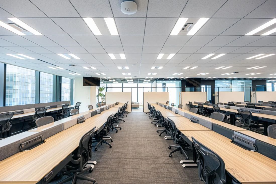 MIXI: Long open office with rows of desks and windows on both sides