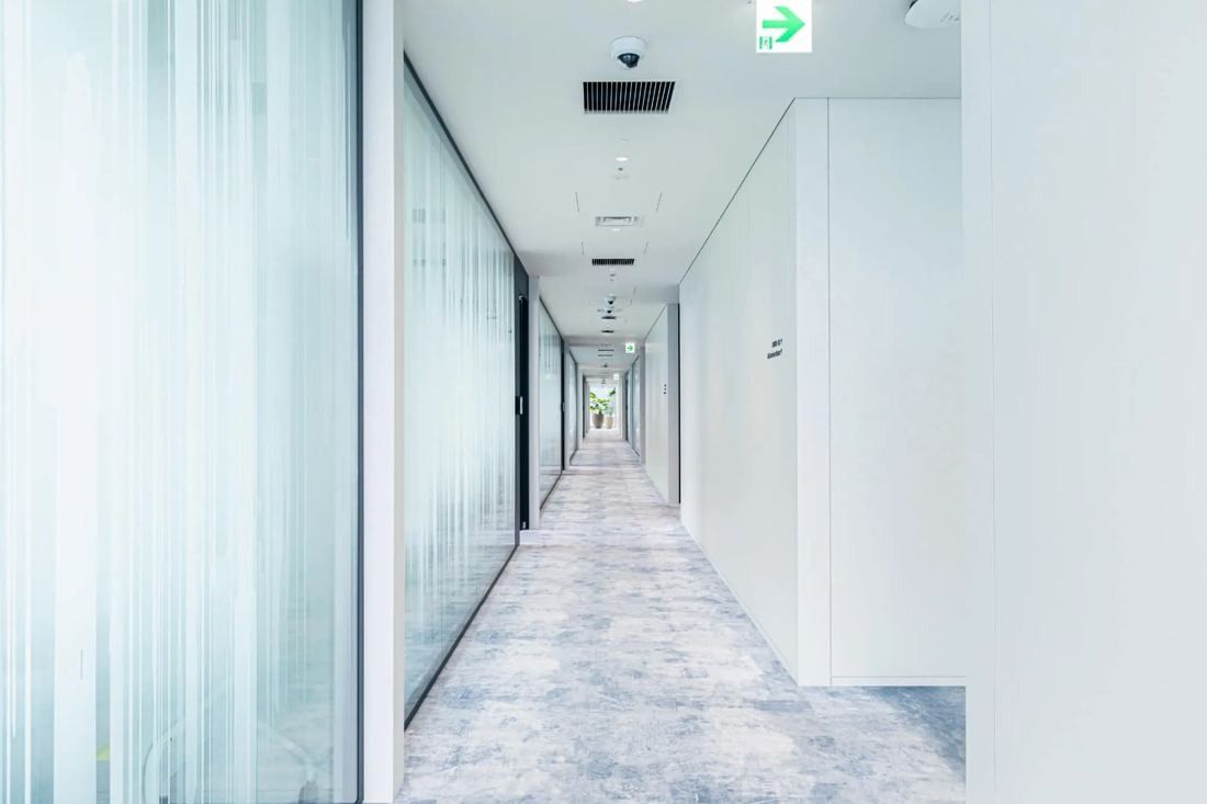 MIXI: Long white corridor with frosted glass walls