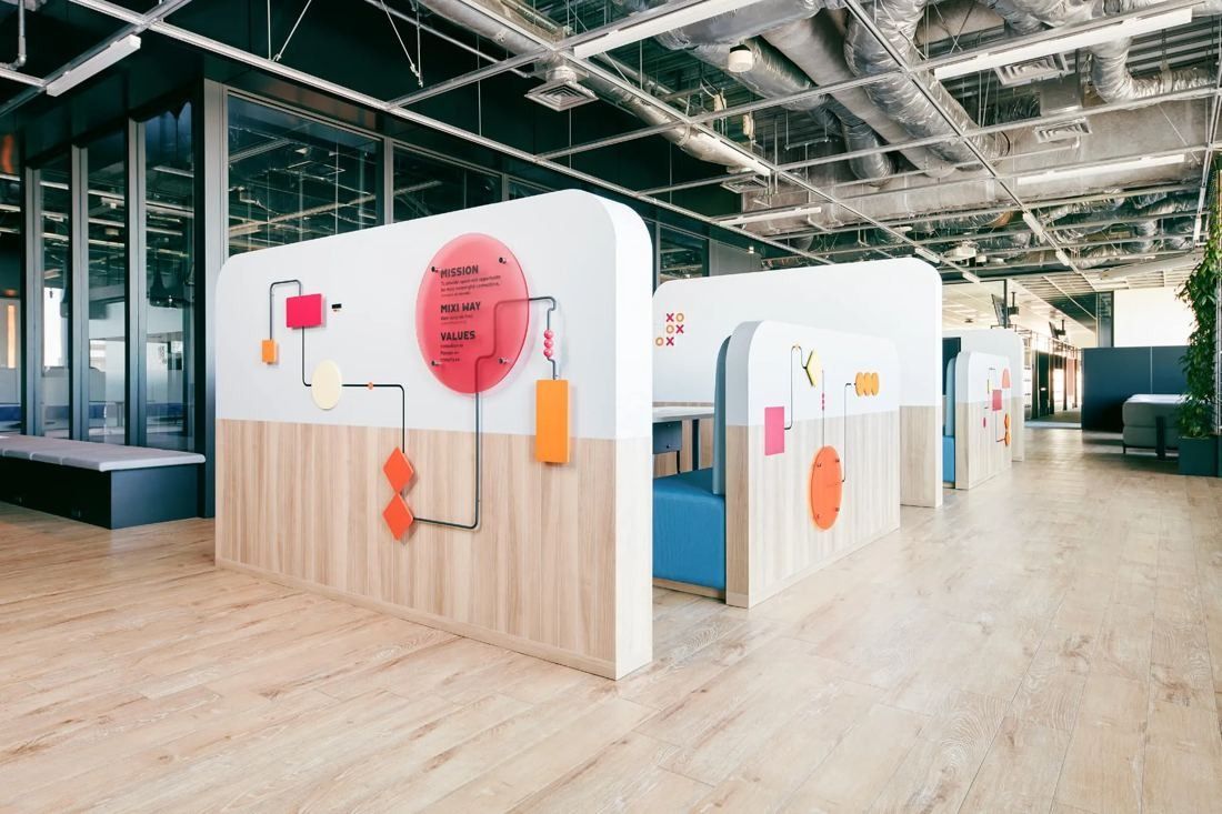 MIXI: Rounded white booths with colourful graphics on a wooden floor