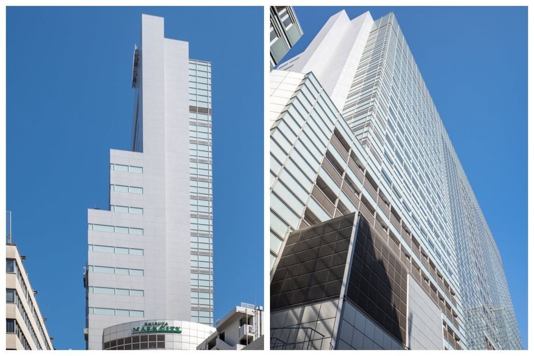 Tall white building and a lower glass-fronted block under blue sky