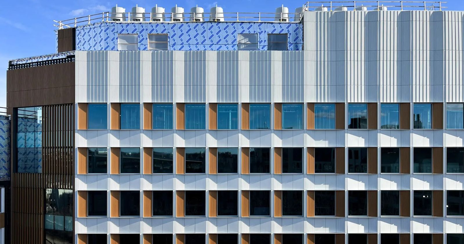 Moderna: Upper floors with vertical white panels and rooftop equipment
