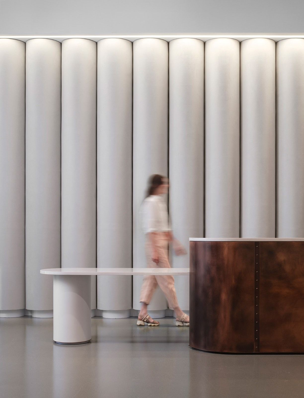 Molson Coors: A curved bench and a wood counter in front of a white fluted wall