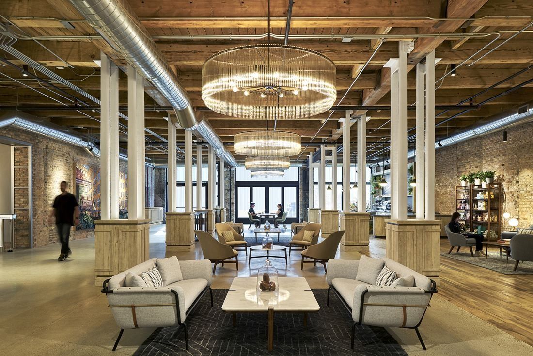 Mondelēz International: Long ground-floor room with timber beams, white columns, round crystal chandeliers and lounge seating
