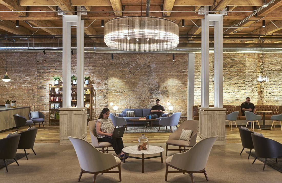Mondelēz International: Lounge with armchairs around low tables under a crystal chandelier, against an exposed brick wall with a drawing