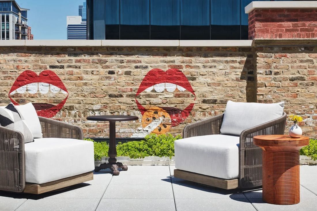 Mondelēz International: Outdoor terrace with white armchairs in front of a brick wall painted with red lips