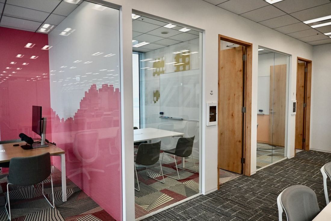 Money Forward: Meeting rooms behind glass doors next to a pink wall graphic