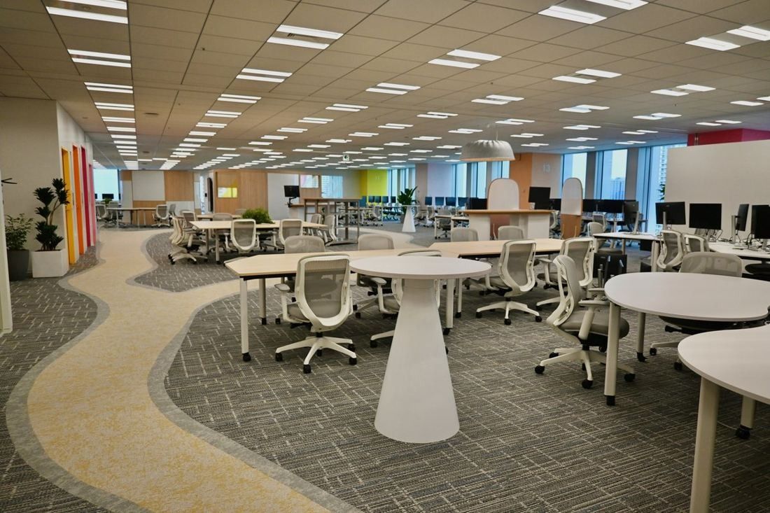 Money Forward: Open floor with round white tables and grey chairs along a curving pale path