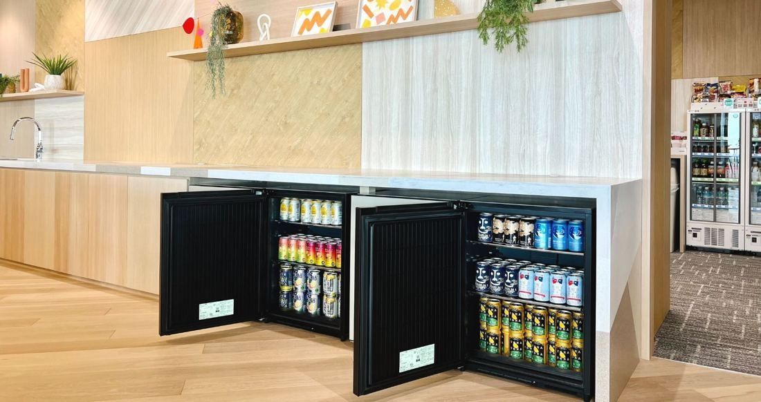 Money Forward: Wooden counter with open glass-front drinks fridges