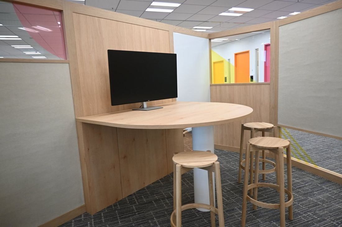 Money Forward: Wooden huddle space with a curved high table, stools and a wall-mounted screen