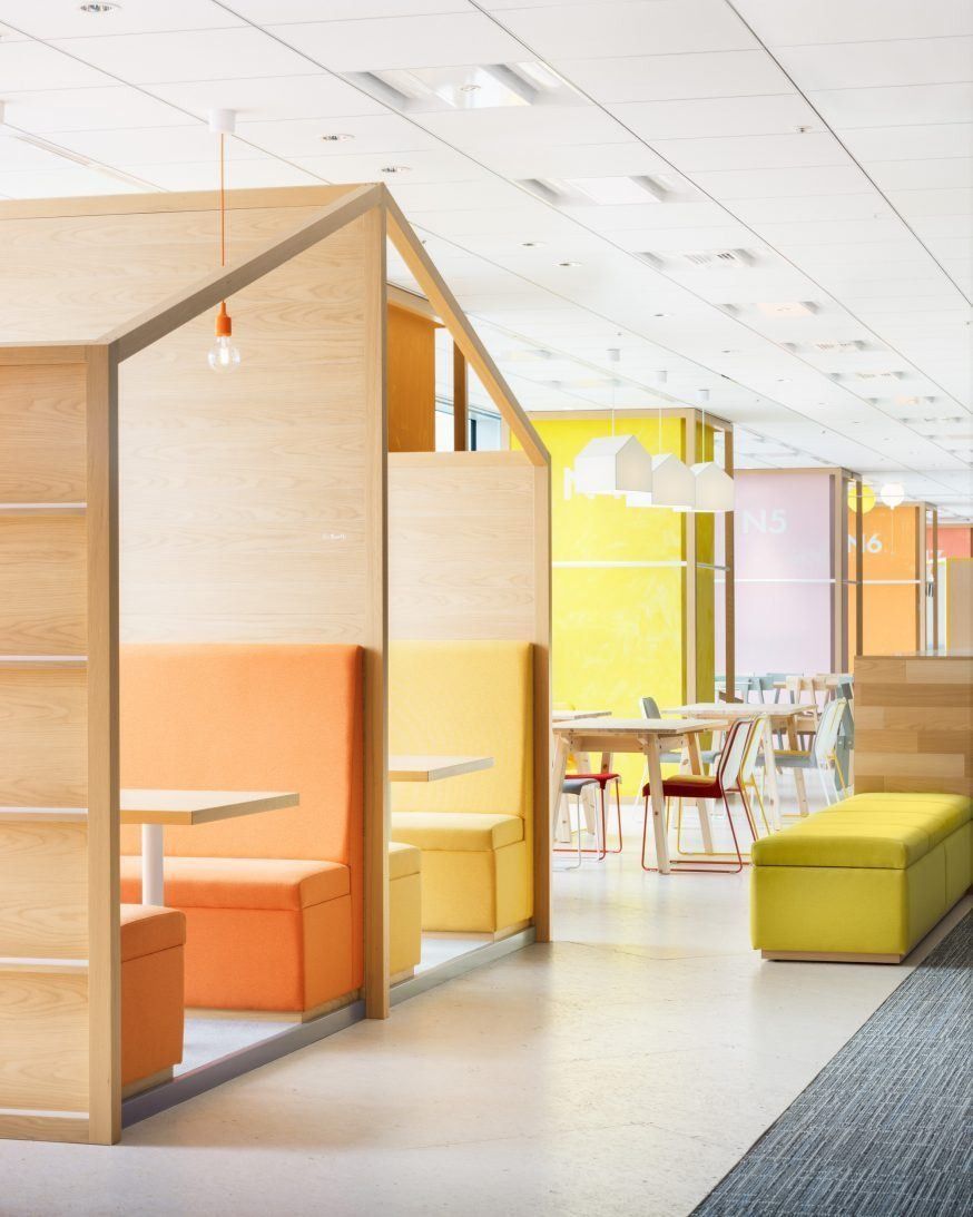 Money Forward: Wooden pod with orange interior and benches beside a yellow sofa