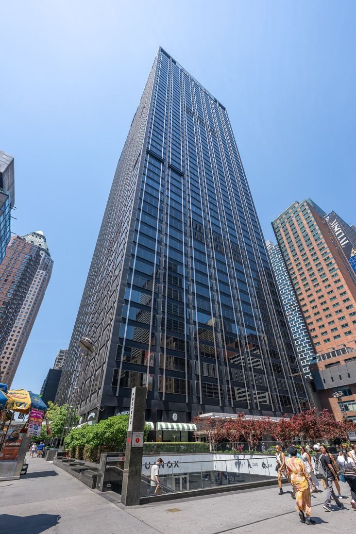 MongoDB: Dark office tower rising above a street-level plaza with trees