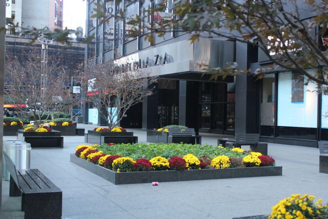 MongoDB: Plaza with granite planters full of yellow and red flowers in front of the building entrance