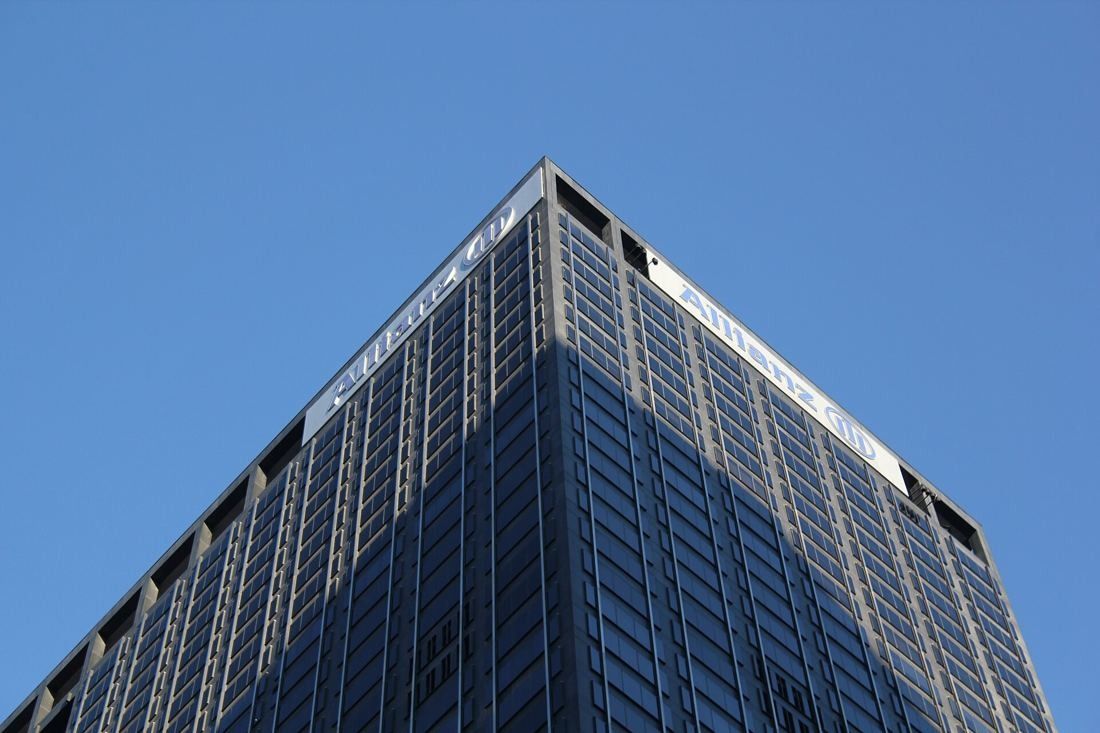 MongoDB: Top corner of a dark office tower against a clear blue sky