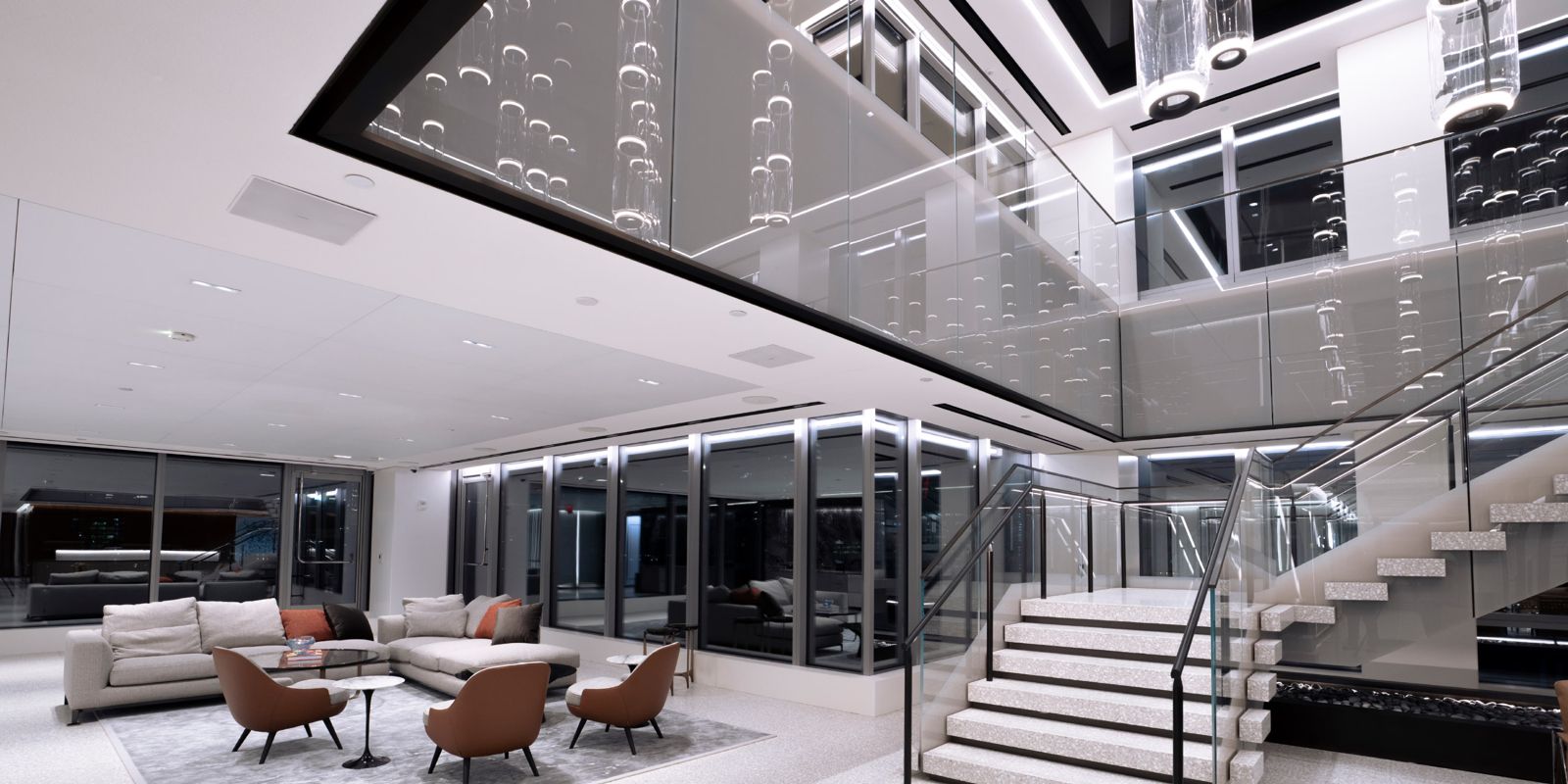 Morgan Stanley: Double-height lounge with a white stair and sofas