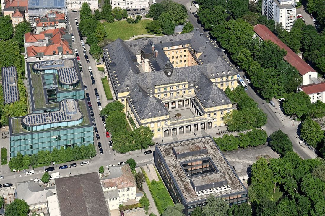 Munich Re: Aerial view of the yellow main building, courtyards and neighbouring office blocks among trees