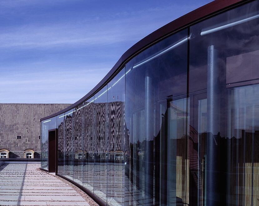 Munich Re: Curved glass façade reflecting an older building